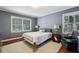 Serene bedroom with hardwood floors, soft lighting, and two large windows at 671 Valley Green Ne Dr, Atlanta, GA 30342