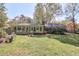 View of backyard with house extension, sunroom, wooden deck, lush grass and mature trees at 1590 Arden Sw Dr, Marietta, GA 30008