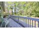 Exterior deck with white chairs and gray railings overlooking the green, wooded backyard at 1590 Arden Sw Dr, Marietta, GA 30008