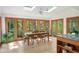 Sun-drenched dining area showcasing a table set for six and large windows overlooking the lush outdoors at 2685 Hearthstone Cir, Marietta, GA 30062