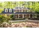 Charming brick home featuring a covered front porch and dormer windows surrounded by lush greenery at 2685 Hearthstone Cir, Marietta, GA 30062