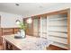 Granite island in kitchen with custom cabinetry, pendant lighting, and pantry with frosted sliding doors at 2685 Hearthstone Cir, Marietta, GA 30062