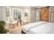 Bright bedroom featuring a sliding barn door, two cushioned chairs and lots of natural light at 393 Westminister Sw Ln, Lilburn, GA 30047