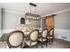 Modern dining room with stylish lighting fixture, a barn door, and neutral decor at 393 Westminister Sw Ln, Lilburn, GA 30047