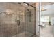 Luxurious tiled shower featuring a glass door, rain shower head, and convenient shelving at 393 Westminister Sw Ln, Lilburn, GA 30047