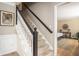 Carpeted staircase with white risers and a dark wood railing leading to the upper floor at 393 Westminister Sw Ln, Lilburn, GA 30047