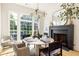 Bright dining room with large windows, fireplace, and contemporary light fixture for elegant dinners at 77 Delmont Ne Dr, Atlanta, GA 30305