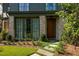 Charming home entrance with stone walkway, green grass, and brick accents, leading to a stylish dark wood door at 77 Delmont Ne Dr, Atlanta, GA 30305