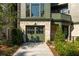A two-car garage door is part of this beautiful house with lush landscaping at 77 Delmont Ne Dr, Atlanta, GA 30305