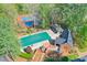 Aerial view of a home with a pool, a patio, and a pool house surrounded by trees at 1991 River Forest Dr, Marietta, GA 30068