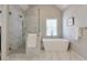 Bright bathroom showcasing a soaking tub and separate glass-enclosed shower with marble surround at 1991 River Forest Dr, Marietta, GA 30068