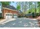 Brick home featuring a spacious driveway, a two-car garage, and mature landscaping at 1991 River Forest Dr, Marietta, GA 30068