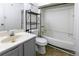 Standard bathroom with white bathtub, toilet, vanity, and black metal storage shelves at 4964 N Ellipse Dr, Marietta, GA 30068