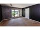 Living room with a brick accent wall, large window, and door with black paint at 4964 N Ellipse Dr, Marietta, GA 30068