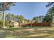Spacious backyard featuring a stone-accented home, green lawn, and a tall wooden fence for privacy at 460 Haynes Creek Circle, Oxford, GA 30054