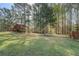 Lush green backyard with mature trees and a wooden fence marking the property line at 460 Haynes Creek Circle, Oxford, GA 30054