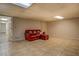 Finished basement area featuring tile flooring and a comfortable red leather sofa with ottoman at 460 Haynes Creek Circle, Oxford, GA 30054