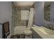Cozy bathroom featuring tile surround, shower-tub combo, and a marble countertop vanity at 460 Haynes Creek Circle, Oxford, GA 30054