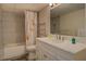 Bright bathroom featuring a shower-tub combo, vanity with ample counter space, and floral shower curtain at 460 Haynes Creek Circle, Oxford, GA 30054