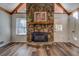 Cozy living room featuring a stone fireplace, wood flooring, and natural light from the window at 460 Haynes Creek Circle, Oxford, GA 30054