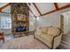 Living room showcases a stone fireplace, hardwood floors, exposed beams, and a comfortable couch at 460 Haynes Creek Circle, Oxford, GA 30054