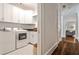 Well-lit laundry room with white cabinets and modern appliances, conveniently located off the hallway at 156 Lake Forrest Ne Ln, Atlanta, GA 30342