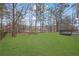 Spacious backyard with a well-maintained lawn, mature trees, and a deck, perfect for outdoor activities and relaxation at 9429 Golfview Pt, Villa Rica, GA 30180