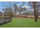 Relaxing backyard featuring mature trees, a lush lawn, and a charming deck with water views at 9429 Golfview Pt, Villa Rica, GA 30180