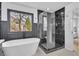 Elegant bathroom featuring a freestanding tub, a glass-enclosed shower, and stylish black and white marble accents at 9429 Golfview Pt, Villa Rica, GA 30180
