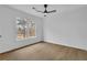 Bright bedroom features a ceiling fan, large window, and wood-look flooring at 9429 Golfview Pt, Villa Rica, GA 30180