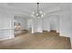 Elegant dining area featuring wainscoting, light floors, a modern light fixture, and archway at 9429 Golfview Pt, Villa Rica, GA 30180