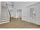 Bright entryway with stairs, white wainscoting, light floors, and archways to other rooms at 9429 Golfview Pt, Villa Rica, GA 30180