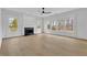 Spacious living room features large windows, a ceiling fan, and a cozy fireplace at 9429 Golfview Pt, Villa Rica, GA 30180