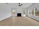 Spacious living room features large windows, a ceiling fan, and a cozy fireplace at 9429 Golfview Pt, Villa Rica, GA 30180