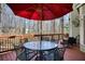Outdoor deck with a table under a large umbrella, plus additional seating and wooded views at 9600 Poplar Ct, Douglasville, GA 30135
