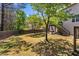 Spacious backyard with a wooden fence, mature trees, and a two-story house with a wooden deck and stairs at 1318 Avington Glen Dr, Lawrenceville, GA 30045