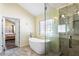 Bathroom showcasing a freestanding tub and a seamless glass shower, with view to bedroom at 1318 Avington Glen Dr, Lawrenceville, GA 30045