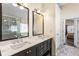 Bathroom with double sink vanity featuring granite counters, sleek black cabinets, and framed mirrors at 1318 Avington Glen Dr, Lawrenceville, GA 30045
