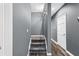 Hallway with gray walls, carpeted stairs, white trim, and hardwood flooring leads to additional rooms at 1318 Avington Glen Dr, Lawrenceville, GA 30045