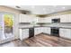 Bright kitchen with white cabinets, stainless steel appliances, hardwood floors and an exterior door at 1318 Avington Glen Dr, Lawrenceville, GA 30045