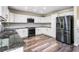 Bright kitchen features white cabinets, stainless steel appliances, granite countertops and hardwood floors at 1318 Avington Glen Dr, Lawrenceville, GA 30045