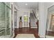 Elegant foyer with beautiful hardwood floors, staircase, and view into a bright, neutral bathroom at 2235 Chestnut Pass, Decatur, GA 30033