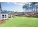 Expansive backyard features a lush lawn, an outdoor fireplace, and a tree-lined landscape at 307 Rockledge Sw Bnd, Powder Springs, GA 30127