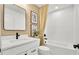This well-lit bathroom features a white vanity, framed mirror, and shower-tub combination at 307 Rockledge Sw Bnd, Powder Springs, GA 30127