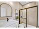 Neutral toned bathroom featuring a walk-in shower with sliding glass doors and a matte black faucet at 307 Rockledge Sw Bnd, Powder Springs, GA 30127