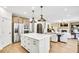 Open-concept kitchen with island seating, stainless steel appliances, and adjacent living and dining areas at 307 Rockledge Sw Bnd, Powder Springs, GA 30127