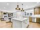 Open-concept kitchen with island seating, stainless steel appliances, and an adjacent living area at 307 Rockledge Sw Bnd, Powder Springs, GA 30127