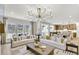 Open-concept living room with a modern chandelier, comfortable seating, and a view of the kitchen at 307 Rockledge Sw Bnd, Powder Springs, GA 30127