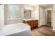 Bright bathroom features double vanity, soaking tub, hardwood flooring and natural light at 3459 Village Park Sw Ln, Atlanta, GA 30331