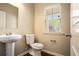 Cozy half bathroom featuring a pedestal sink and window bringing in natural light at 3459 Village Park Sw Ln, Atlanta, GA 30331